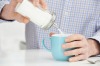 Mature Man Adding Sugar To Cup Of Coffee