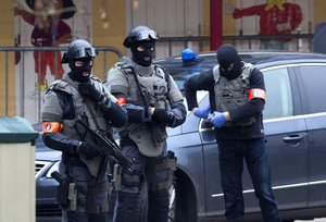 Special operations police secure an area during a police raid in the Molenbeek neighbourhood of Brussels, Belgium on Friday, March 18, 2016.