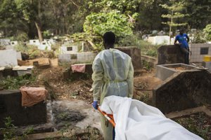 The Red Cross is undertaking safe and dignified burials in all Ebola-affected countries, ensuring that those who have died from the disease are treated with respect, while also ensuring the safety of communities. This is critical work, often performed by volunteers, and undertaken at the most dangerous time.Volunteers must wear full personal protective equipment and work in teams of seven. Seen here is a team who is carrying the body of a 40 year-old woman who died from Ebola virus and has been transported from Donka Hospital to the Conakry Cemetary to be buried. The team is transporting the body from the truck to the grave.  UNMEER/Martine perret. 16 January 2015