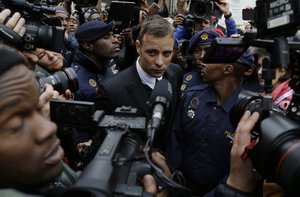 Oscar Pistorius, is escorted by police officers as he leaves the High Court in Pretoria, South Africa, Tuesday, June 14, 2016, after his sentencing proceedings.