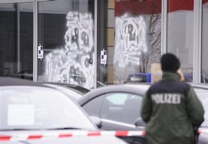 A police officer secures the crime scene at a car dealer in Wendlingen, Germany, Thursday, March 12, 2009. The 17-year-old gunman opened fire at his former Albertville high school in Winnenden, southwestern Germany on Wednesday, killing 15 people before taking his own li