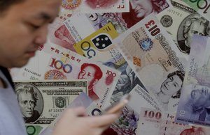 A man walks past a poster showing British pound and other countries' banknotes in Hong Kong, Friday, June 24, 2016.