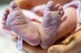 Newborn baby feet and hands of the mother.