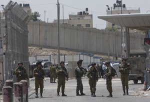 Israeli army soldiers secure the main entrance of the Qalandia checkpoint, a main crossing point between Jerusalem and the West Bank city of Ramallah, Wednesday, April 27, 2016. Israeli security forces shot and killed two young Palestinians, including a woman, who attempted to carry out a stabbing attack at the Qalandia checkpoint, Israeli police said. (AP Photo/Nasser Nasser)