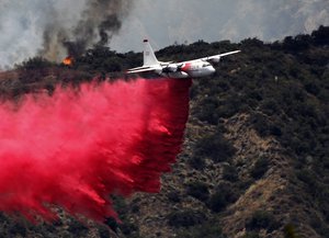 A firefighting aircraft makes a low altitude pass to drop fire retardant to battle a wildfire near Bradbury, Calif. on Wednesday, June 22, 2016.