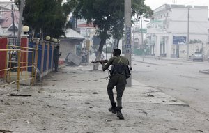 A Somali soldier takes position during an attack on Nasahablod Hotel, in Mogadishu, Somalia, Saturday, a June 25, 2016.