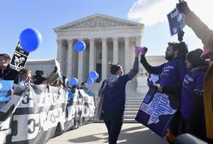 Pro-abortion rights protester Lauren Rankin of New York City, left, gets a high five from Sarp Aksel of New York City, as they and anti-abortion protesters, left, rally outside the Supreme Court in Washington, Wednesday, March 2, 2016.