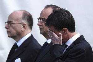 Prime Minister Manuel Valls, right, French President Francois Hollande and French Interior Minister Bernard Cazeneuve attend a ceremony for the two police officials killed by an extremist claiming allegiance to IS, during a ceremony, Friday, June 17, 2016 in Versailles, near Paris.