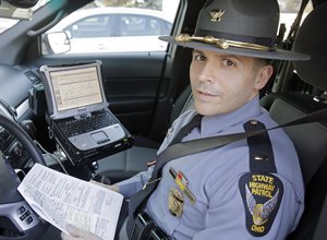 In this Wednesday, Jan. 28, 2015 photo, Ohio State Highway Patrol Lt. Antonio Matos demonstrates the electronic citation system inside a patrol car at the Cleveland Metro Post in Brook Park, Ohio.