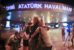 Passengers embrace each other on the entrance to Istanbul's Ataturk airport, early Wednesday, June 29, 2016 following its evacuation after a blast.