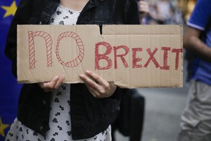 A woman holds a poster during a protest opposing Britain's exit from the European Union in Berlin