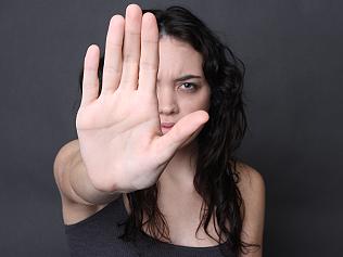 angry girl holds up her hand to stop pretator and end the cycle of abuse