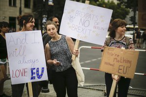 Women hold posters during a protest opposing Britain's exit from the European Union in Berlin, Saturday, July 2, 2016.