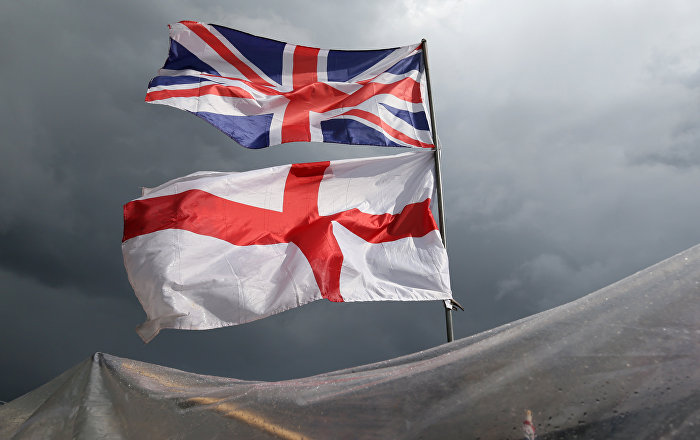 The flag of the United Kingdom of Great Britain and Northern Ireland, top, and the flag of England fly above a souvenir stand on Westminster Bridge following yesterday's EU referendum result, London, Saturday, June 25, 2016. Britain voted to leave the European Union after a bitterly divisive referendum campaign.