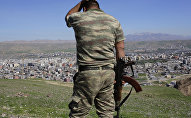 A Turkish soldier gestures while standing on the hill overlooking damaged buildings following heavy fighting between government troops and Kurdish fighters in the Kurdish town of Cizre in southeastern Turkey, which lies near the border with Syria and Iraq, on March 2, 2016