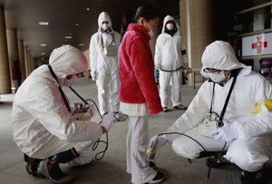 In this March 24, 2011 file photo, a young evacuee is screened at a shelter for leaked radiation from the tsunami-ravaged Fukushima Dai-ichi nuclear power plant in Fukushima, northeast of Tokyo.