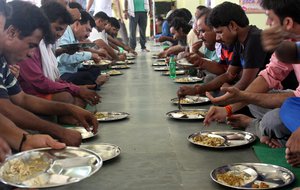 File - Indian Hindu pilgrims bound for Amarnath pilgrimage sit in a queue to eat food distributed for free at Bhagwati Nagar Yatri Niwas in Jammu, India, 30 June 2016.