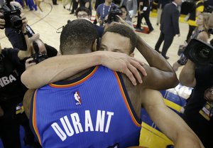 Oklahoma City Thunder forward Kevin Durant, foreground, hugs Golden State Warriors guard Stephen Curry after Game 7 of the NBA basketball Western Conference finals in Oakland