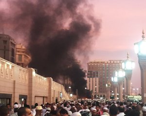 In this photo provided by Noor Punasiya, people stand by an explosion site in Medina, Saudi Arabia, Monday, July 4, 2016. State-linked Saudi news websites reported an explosion Monday near one of Islam's holiest sites