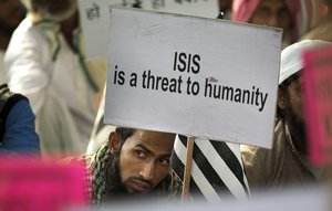 man holds a banner during a protest against ISIS, an Islamic State group.