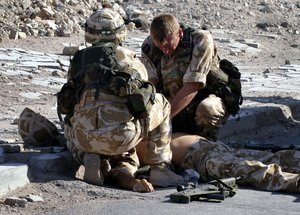 British soldiers try to save the life a fellow soldier following a roadside explosion in the southern city of Basra, Iraq, Monday, June 28, 2004.