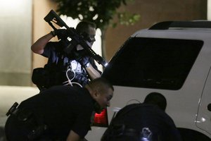 Dallas police check a car after detaining a driver in downtown Dallas, Thursday, July 7, 2016. Several police officers were shot by snipers, police said; some of the officers were killed.