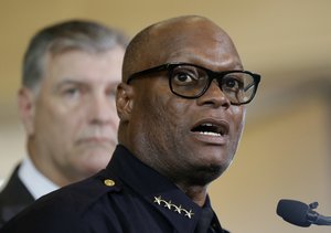 Dallas police chief David Brown, front, and Dallas mayor Mike Rawlings, rear, talk with the media during a news conference, Friday, July 8, 2016, in Dallas.