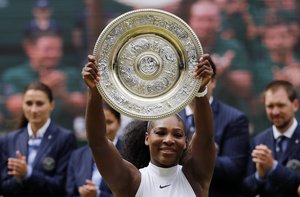 Serena Williams of the U.S raises the trophy after beating Angelique Kerber of Germany in the women's singles final on day thirteen of the Wimbledon Tennis Championships in London, Saturday, July 9, 2016.