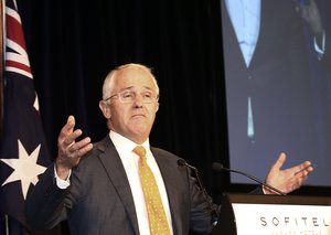 Australia's Prime Minister Malcolm Turnbull raises his arms as he addresses a reception on election night in Sydney, Australia, Sunday, July 3, 2016.