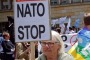 A woman holds a banner during an anti-NATO protest joined by hundreds in Warsaw, Poland, on Saturday.