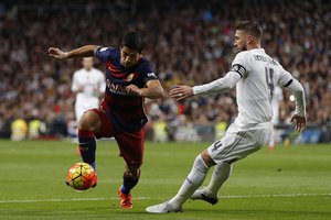 Real Madrid's Sergio Ramos, right, duels for the ball with Barcelona's Luis Suarez during the first clasico of the season between Real Madrid and Barcelona at the Santiago Bernabeu stadium in Madrid, Spain, Saturday, Nov. 21, 2015