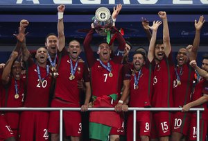 Portugal's Cristiano Ronaldo lifts the trophy after winning the Euro 2016 final soccer match between Portugal and France at the Stade de France in Saint-Denis, north of Paris, Sunday, July 10, 2016.