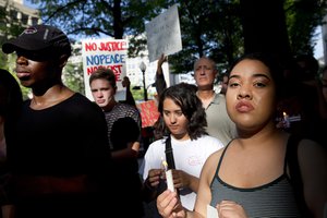 Thomas Lyile, 20, left, of Washington, Marley Hillman, 17, center, of Bethesda, Md., and Alisey Corrales, 17, of Arlington, Va., rally in front of the Department of Justice in Washington, Friday, July 8, 2016.