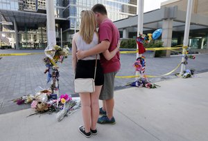 Autumn Backs, left, and her friend Jordan Johnson take a moment to pray in front of a makeshift memorial near Thursday night's crime scene, Sunday, July 10, 2016, in Dallas.