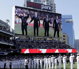 The Tenors, shown on the scoreboard, perform during the Canadian National Anthem prior to the MLB baseball All-Star Game, in San Diego. A member of a Canadian singing quartet changed a lyric in his country's national anthem and held up a sign proclaiming "All Lives Matter" during a pregame performance at the 87th All-Star Game on Tuesda