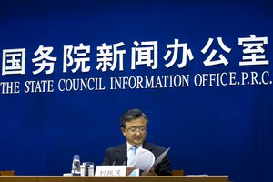 China's Vice Foreign Minister Liu Zhenmin looks at the white policy paper on South China Sea during a press briefing at the State Council Information Office in Beijing, Wednesday, July 13, 2016. China blamed the Philippines for stirring up trouble