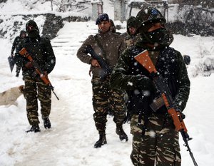 Indian Army soldiers patrol during fresh snowfall in Tangmarg road some 45 kilometers north of Srinagar on Monday 04, January 2015. Srinagar city  witnessed the season's first major snowfall along with the rest of Kashmir, bringing respite from the prevailing chill as the mercury settled above the freezing point in most places of the valley for the first time in the last fortnight.