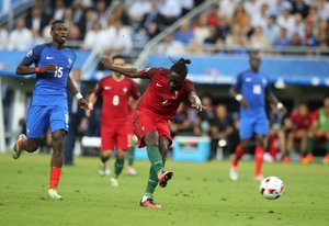 Portugal's Eder, center, scores the opening goal during the Euro 2016 final soccer match between Portugal and France at the Stade de France in Saint-Denis, north of Paris