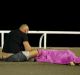 A man sits next to a body seen on the ground July 15, 2016 after at least 30 people were killed in Nice, France, when a ...