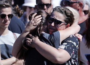 Women react near the scene where a truck mowed through revelers in Nice, southern France, Friday, July 15, 2016.