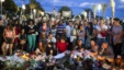 People gather at a makeshift memorial to honor the victims of an attack, near the area where a truck mowed through revelers in Nice, France, July 15, 2016. 