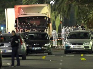 Forensic officers stand near a truck with its windscreen riddled with bullets, that plowed through a crowd of revelers who'd gathered to watch the fireworks in the French resort city of Nice, southern France, Friday, July 15, 2016.