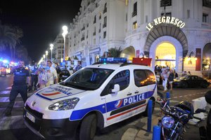 A Police car is parked near the scene of an attack after a truck drove on to the sidewalk and plowed through a crowd of revelers who'd gathered to watch the fireworks in the French resort city of Nice, southern France, Friday, July 15, 2016.