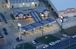 In this aerial photo, investigators work the shooting scene in Baton Rouge, La., where several law enforcement officers were either shot or killed, Sunday, July 17, 2016.