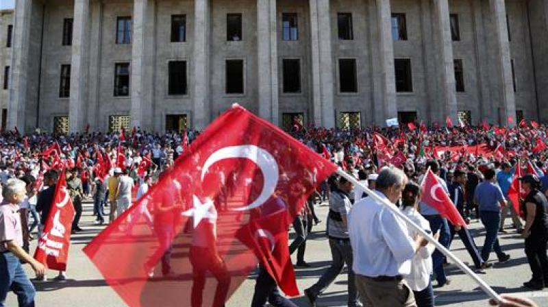 Turkish citizens wave their national flags as they protest against the military coup outside Turkey's parliament near the Turkish military headquarters in Ankara, Turkey. (Photo: AP)