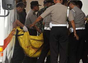 Indonesian police officers carry one of the two bodies of militants killed by Indonesian security forces upon arrival at the police hospital in Palu, Central Sulawesi, Indonesia, Tuesday, July 19, 2016.