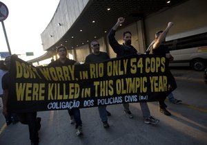 Policemen holds a banner while they arrive to the Tom Jobim International Airport, during a protest, demanding their payments and better labor conditions, at the Tom Jobim International Airport, in Rio de Janeiro, Brazil