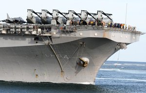 Navy personnel from the U.S Wasp class amphibious assault ship USS Boxer stand on deck as the ship sail past the Likoni channel headed to dock at the port of Mombasa, Kenya Monday, April 20, 2009.