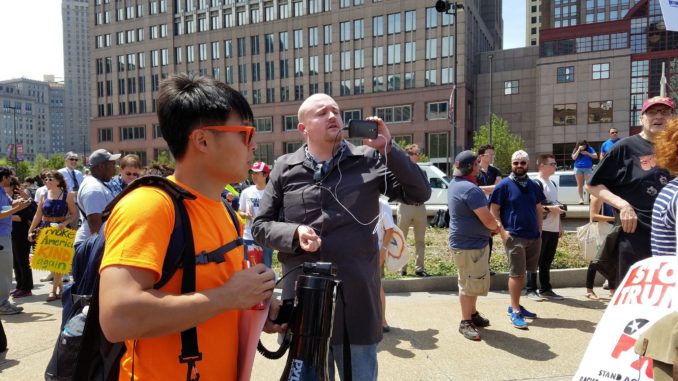 Matt Forney, center holding smartphone, live streaming for White Supremacist Red Ice
