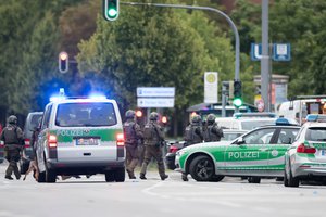 Heavily armed police forces stand outside the Olympia shopping centre where several people have been killed in a shooting in Munich, southern Germany, Friday, July 22, 2016.